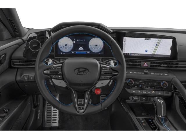 Interior showing the steering wheel with blue accents, digital instrument cluster, and center infotainment screen.