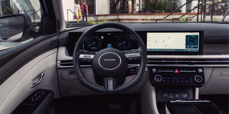 The interior of a modern car with a view of the steering wheel, digital dashboard, and navigation screen.
